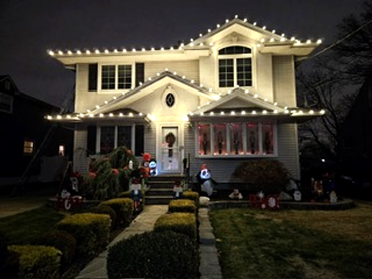 Warm white C9 LED roofline and bush holiday lighting installed on a colonial home in Bergen County, NJ